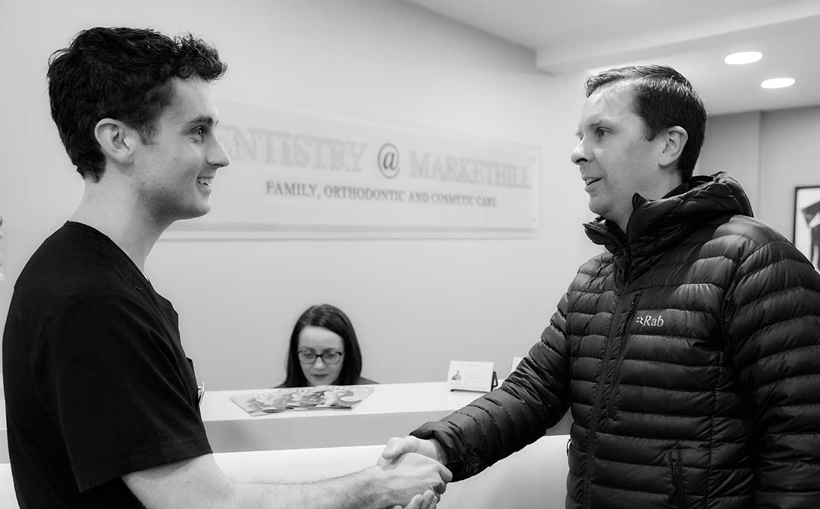 Dentist Stuart Black meeting a patient at Reception